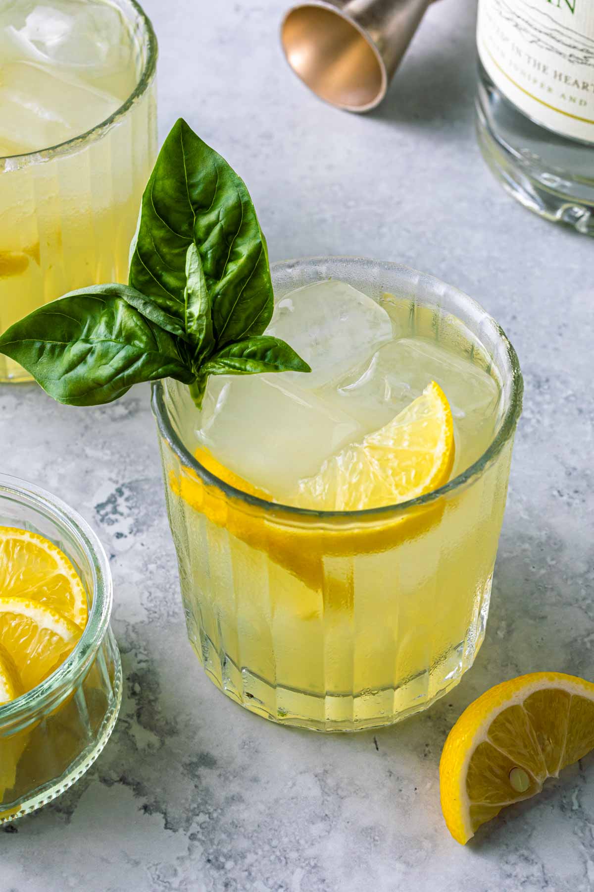 gin smash cocktail garnished with lemon and basil