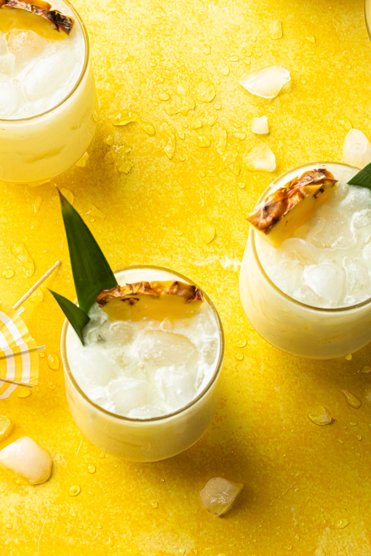 Overhead shot of a few pina coladas on the rocks made with coconut milk.