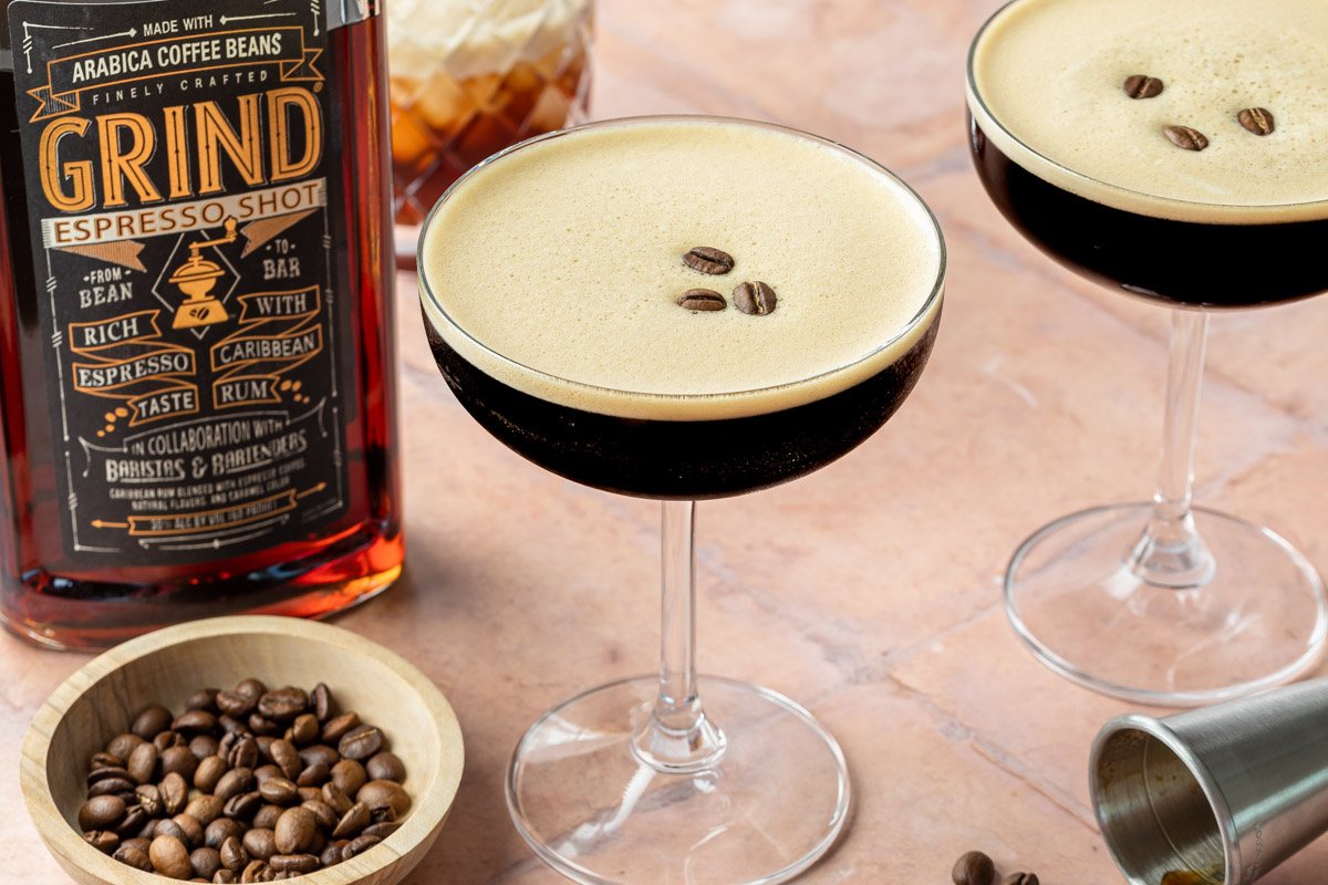 Two espresso martinis made with tequila in coupe glasses, garnished with espresso beans. 