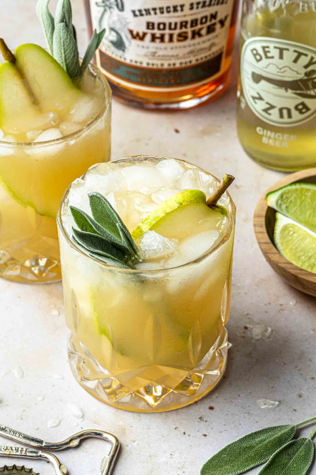 bourbon cocktail garnished with sage and pears
