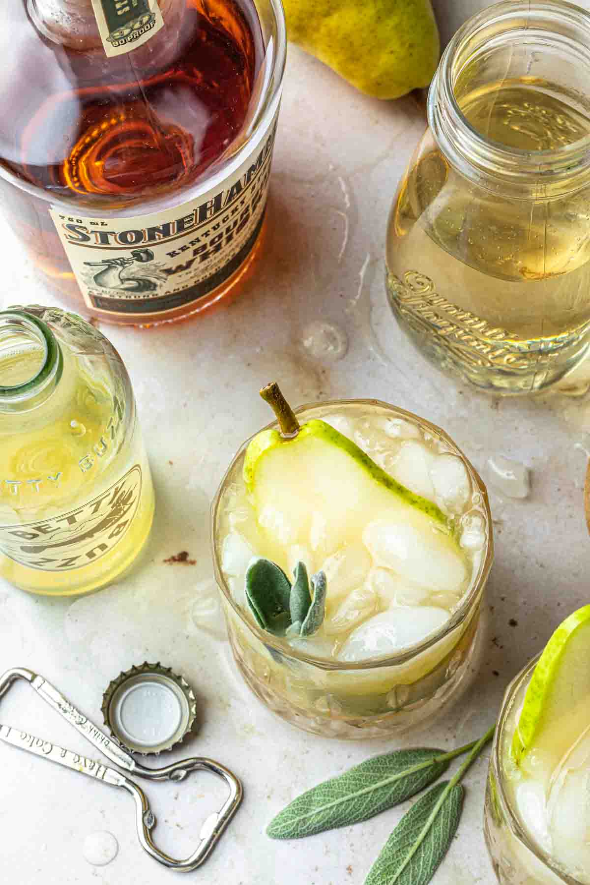 overhead view of a pear cocktail with bottles of ingredients around it