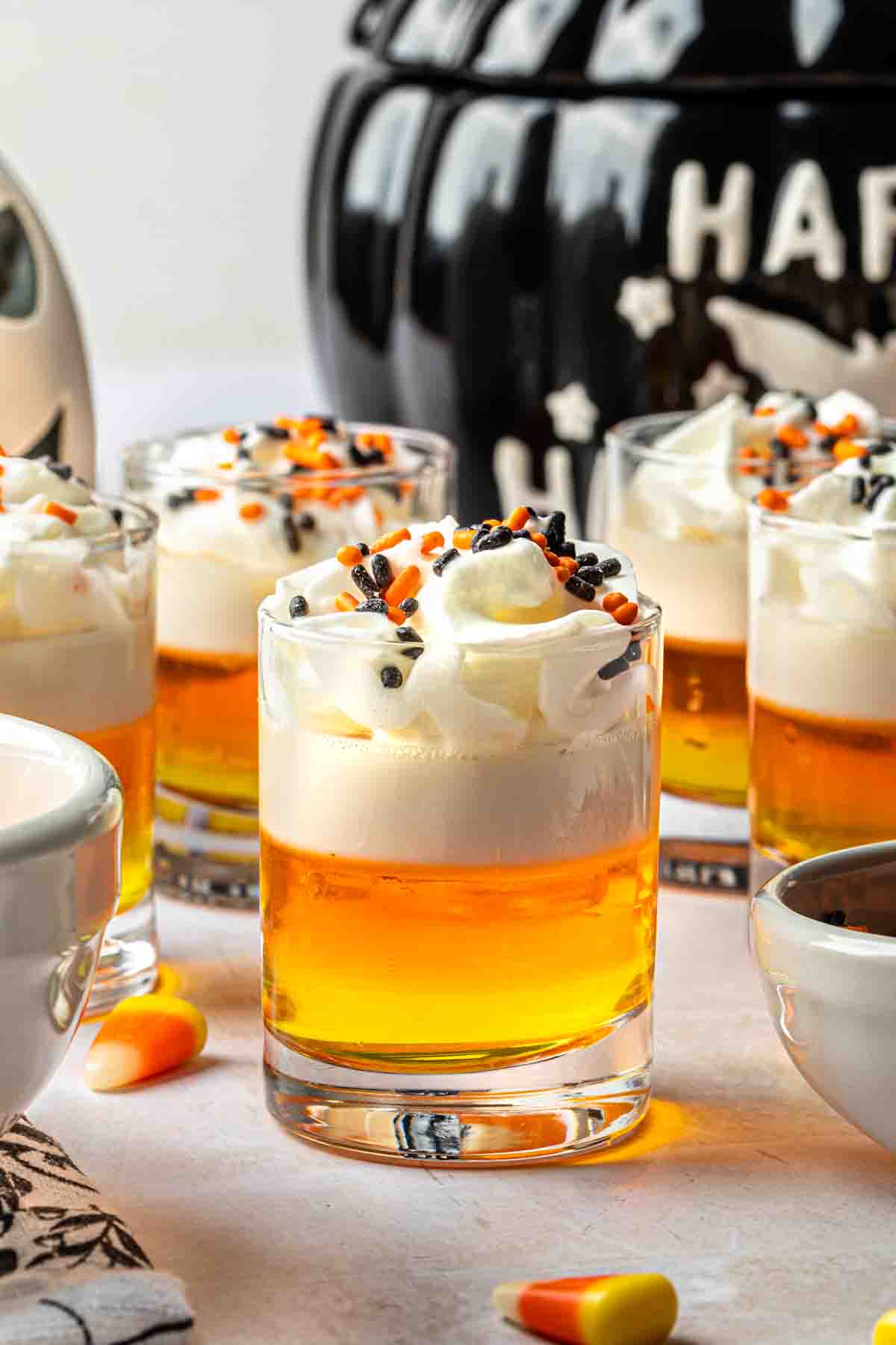 Candy corn shot garnished with whipped cream and halloween sprinkles.