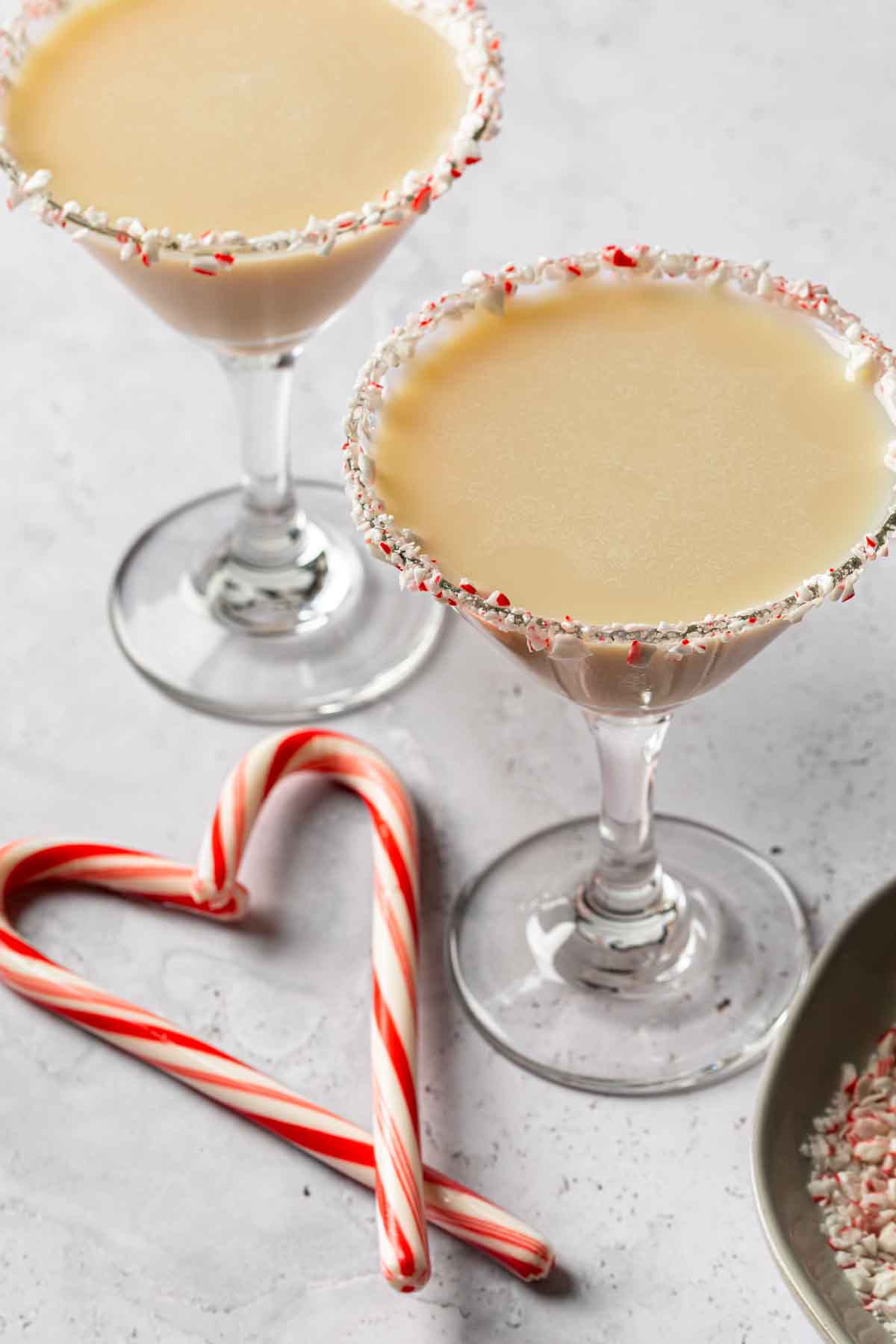 2 peppermint martinis next to some candy canes. 