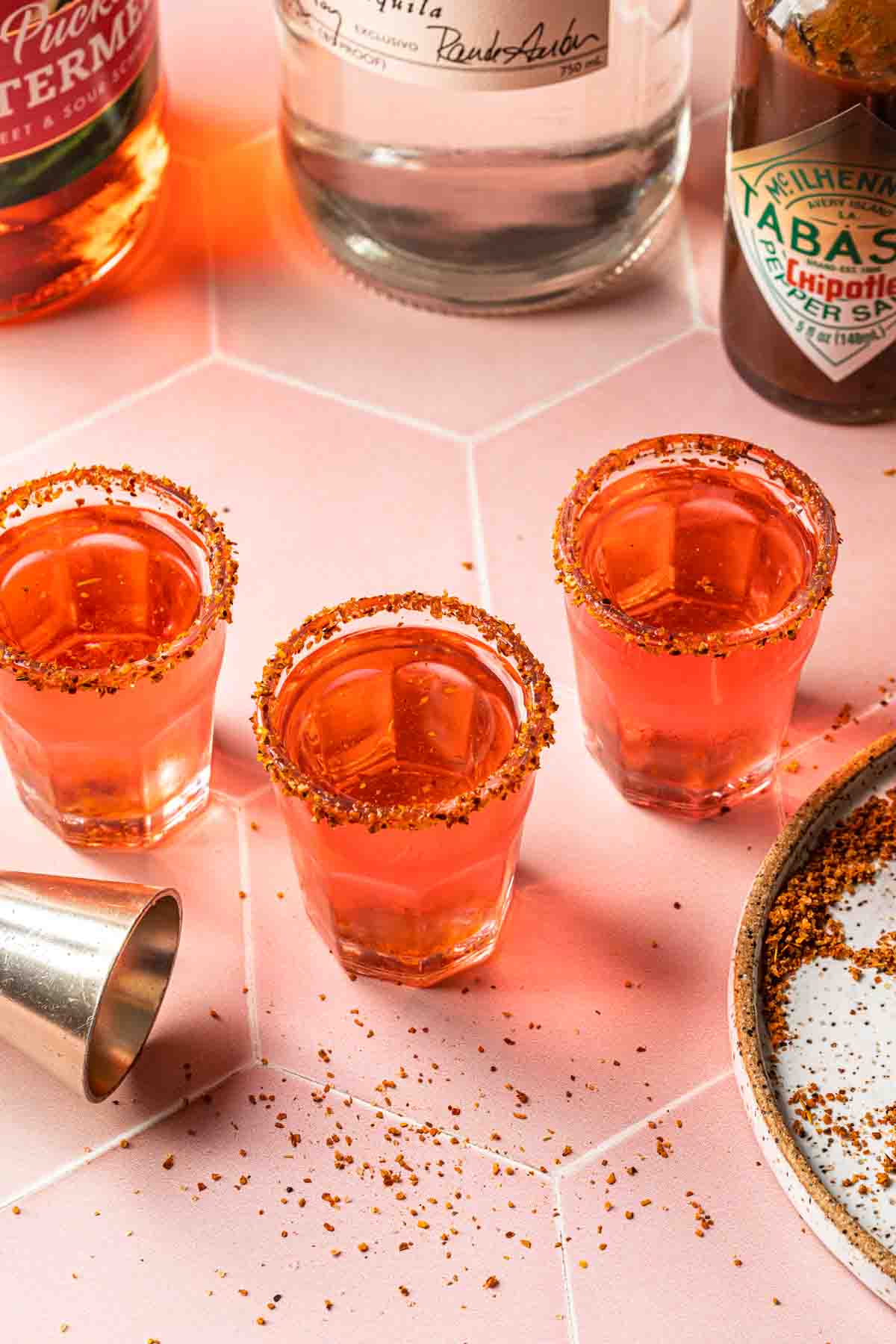 3 mexican candy shots in shot glasses rimmed with tajin. 