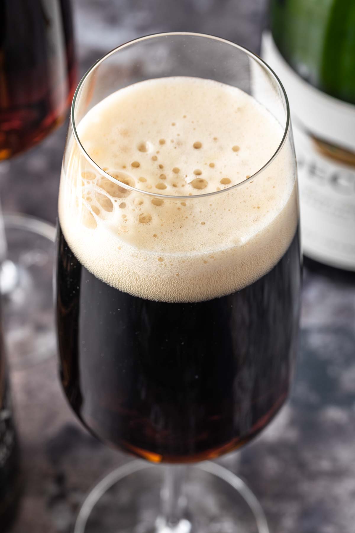 Close up of a black velvet drink in a champagne glass, showing the foamy head of the cocktail. 