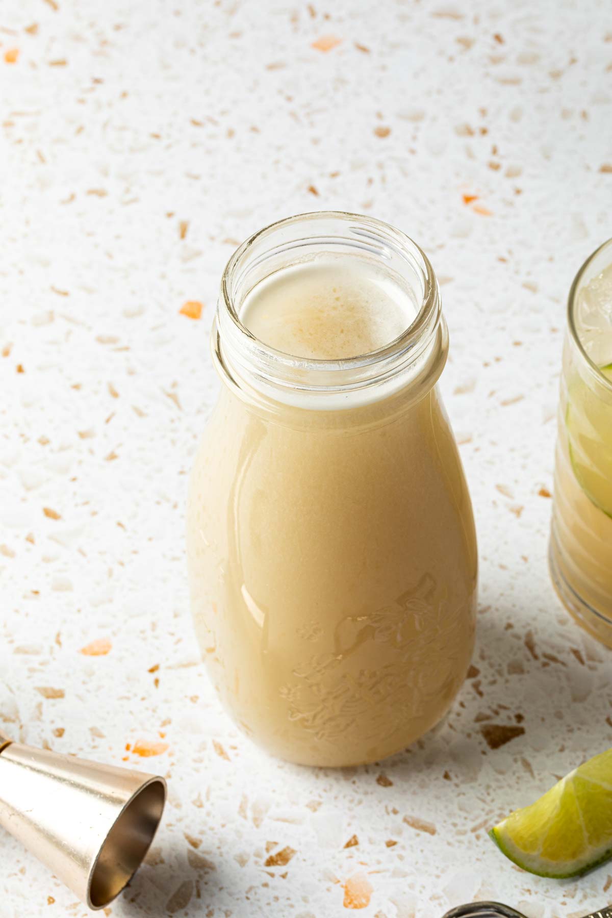 A bottle of homemade rich simple syrup made from almond milk. 