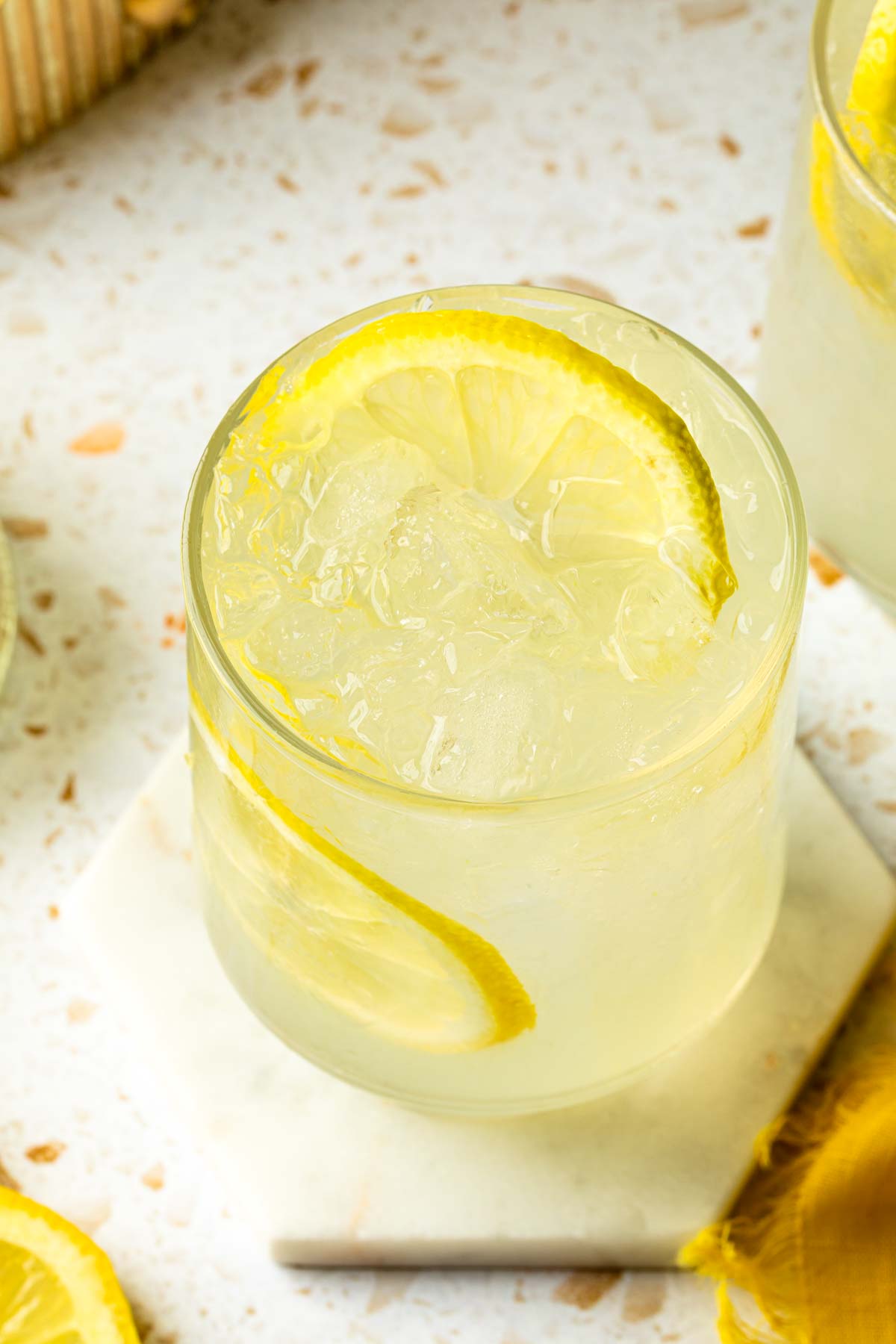 A glass of lemonade with a lemon wheel for garnish. 