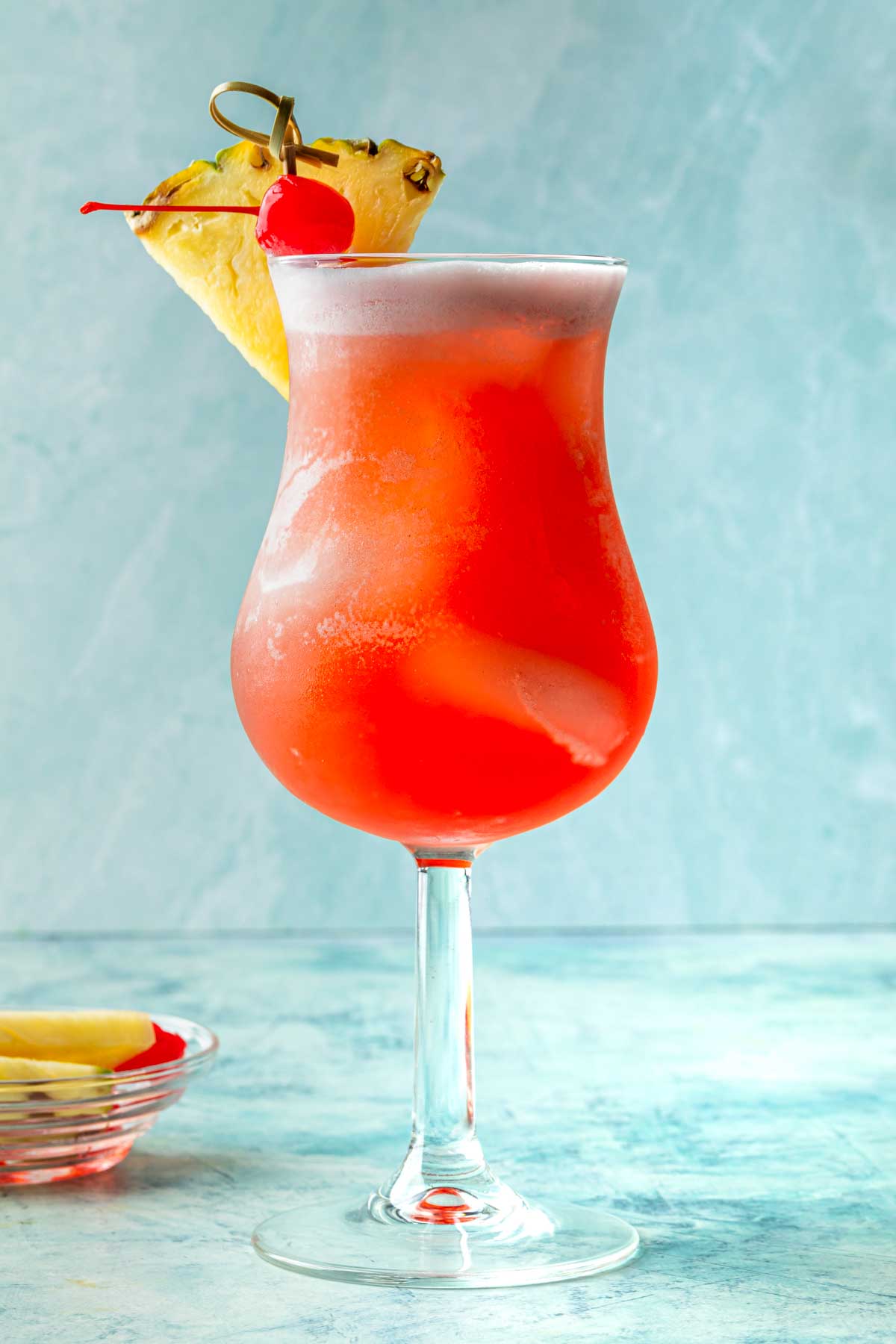 A malibu bay breeze in a tropical cocktail glass, garnished with a pineapple wedge and a maraschino cherry. 