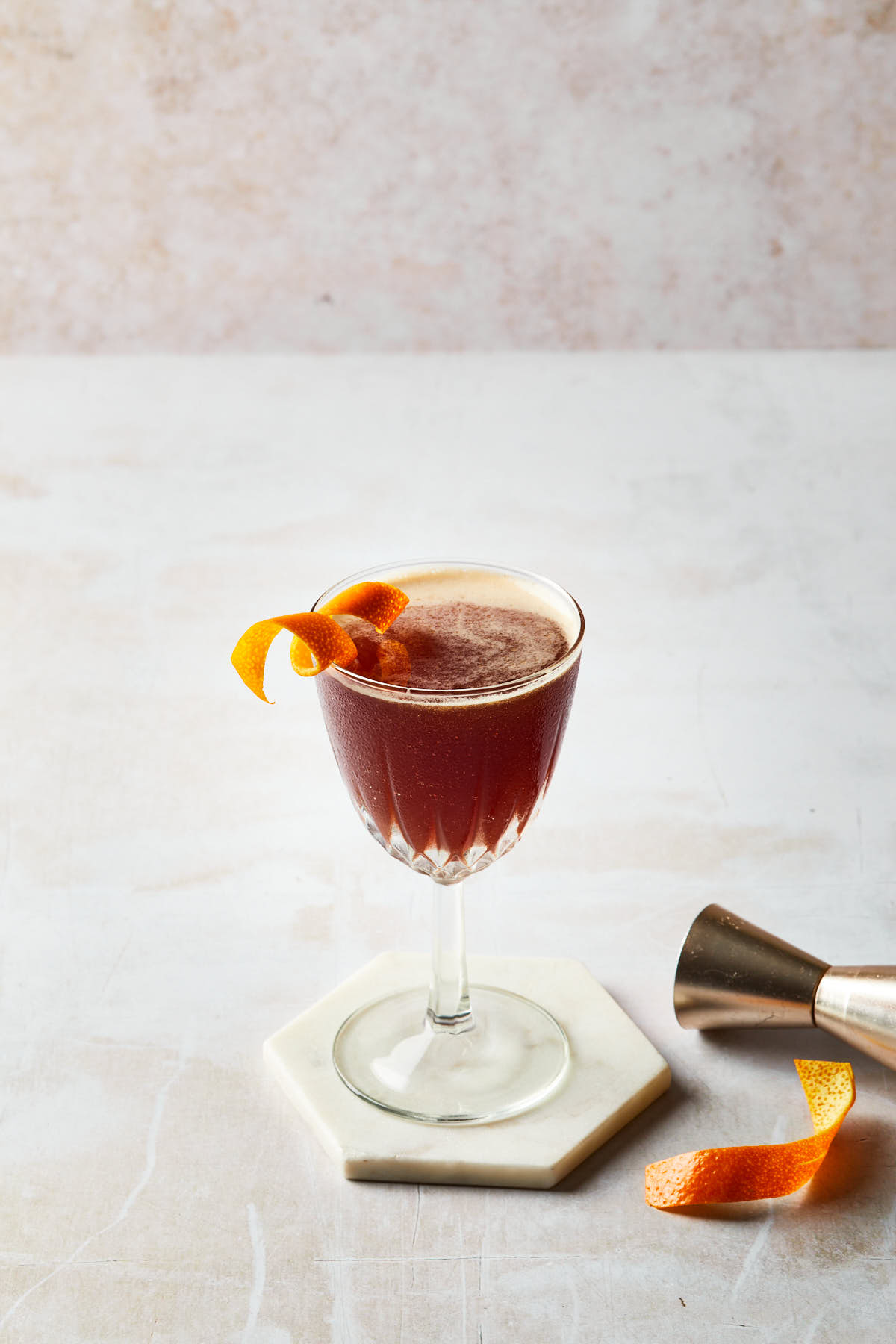A blood and sand cocktail garnished with an orange twist. 
