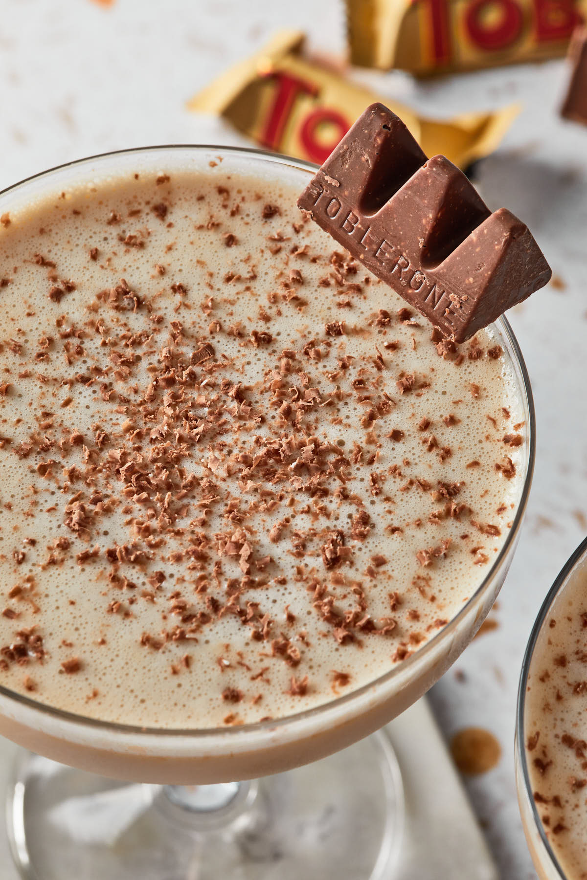 Close up of a creamy chocolate toffee martini with shaved chocolate bits floating on top as garnish. 